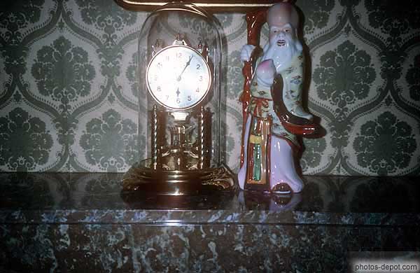 photo d'horloge et statue de porcelaine