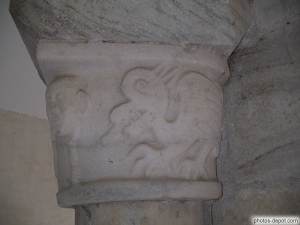 photo de tête et Griffon sculptés sur chapiteau de colonne du Cloître