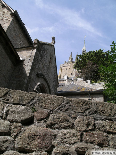 photo de derrière le mur : Statue de Jeanne d'Arc, église paroissiale et Abbaye