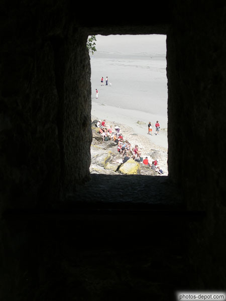 photo de la plage devant le mont vue d'une lucarne dans le rempart
