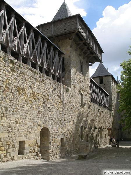 photo de muraille du chateau surmonté du hourd de bois