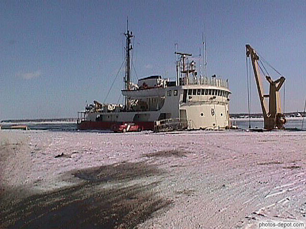 photo de bateau derrière le quai enneigé