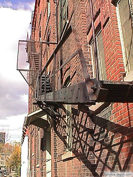 photo d'escaliers de secours en fer sur les facades de briques