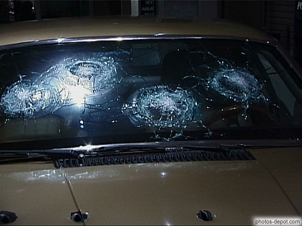 photo d'impacts de balle dans pare brise et coffre de voiture