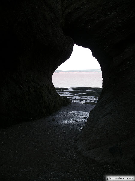 photo de Passage sous un rocher sur la grève à marée basse