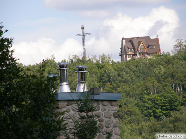 photo de Croix de fer, cheminées et maison dépassent de la forêt