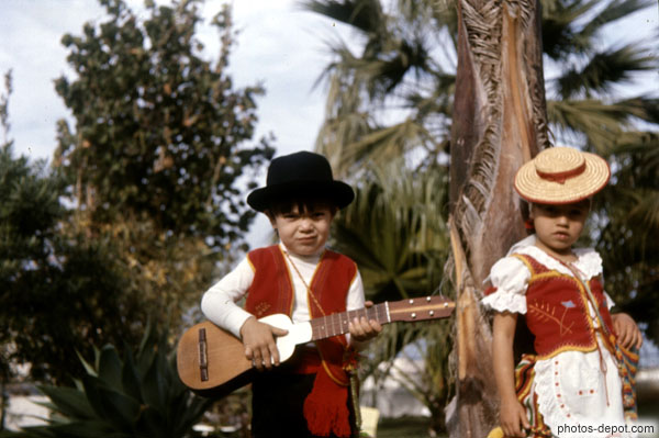 photo d'enfants en costume jouant de la musique avec petite guitare