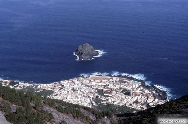 Rocher dans la mer et village en demi-cercle