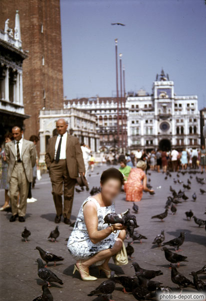photo de femme aux pigeons devant tour de l'horloge