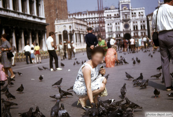 photo de femme aux pigeons devant tour de l'horloge
