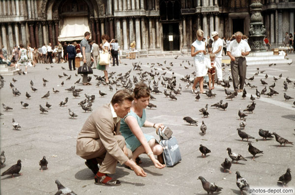 photo de couple nourrissant les pigeons