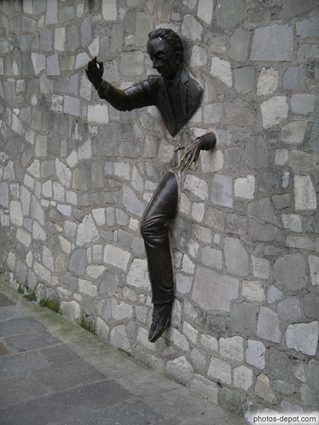 photo de statue d'homme sortant du mur