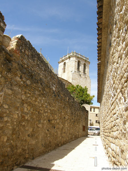 photo de rue bordée de hauts murs menant à la tour du monastère Sant Pere fondé en 977