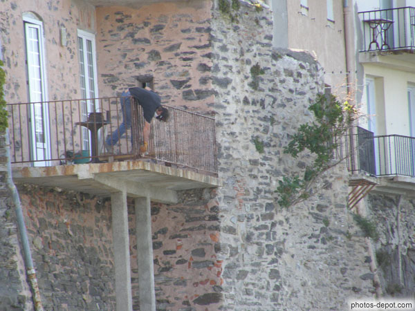 photo d'homme penché sur son balcon