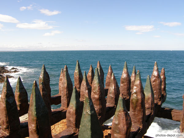 photo de pointes de fer rouillées face à la mer