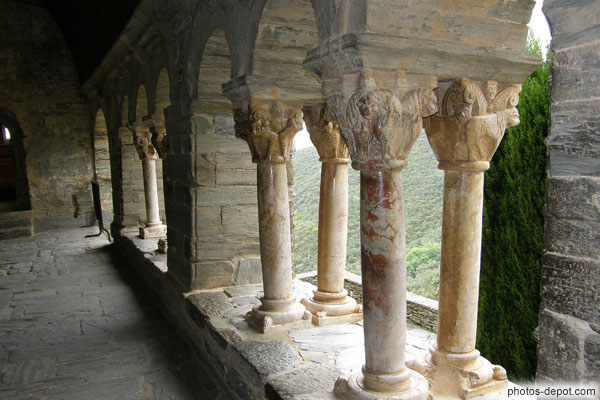 photo de 8 colonnes jumelées aux chapiteaux finement sculptés de la galerie unique du cloître