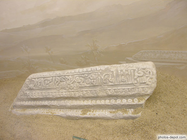 photo de Pierre tombale arabe du 11e siècle connue dans les pays islamiques sous le nom de MQABRIYA. Inscription de fragments de la soixantième sourate , versets 1, 4 et 5, ornementation végétaux, rangs perlés