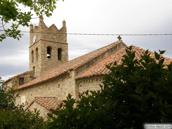 photo d'Eglise au clocher quadrangulaire émergeant de la toiture de tuiles romanes
