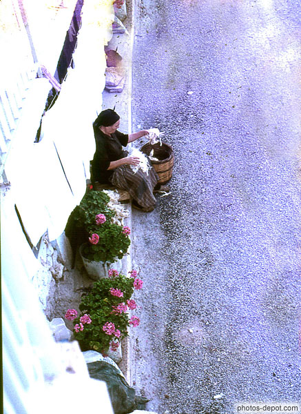 photo de femme au panier assise sur trottoir