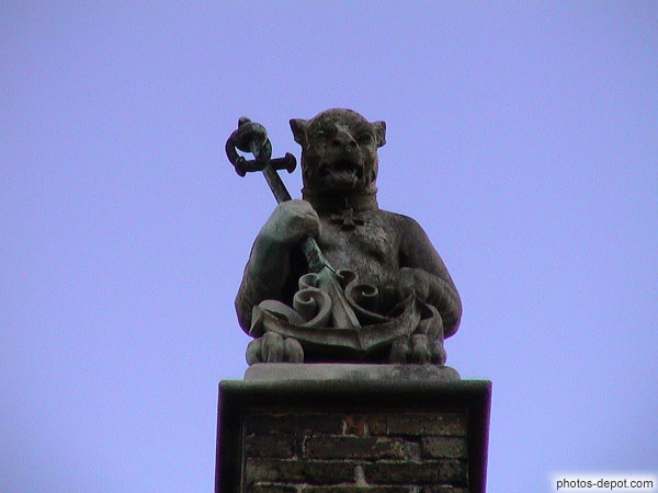 photo de statue animal portant ancre au sommet maison pignons