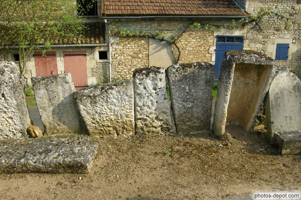 photo de sarcophages mérovingiens fichés en terre formant les murs du cimetière