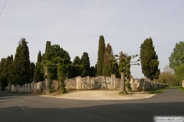 photo de murs de la nécropole constitués des couvercles de sarcophages mérovingiens ornés de la croix à 3 traverses
