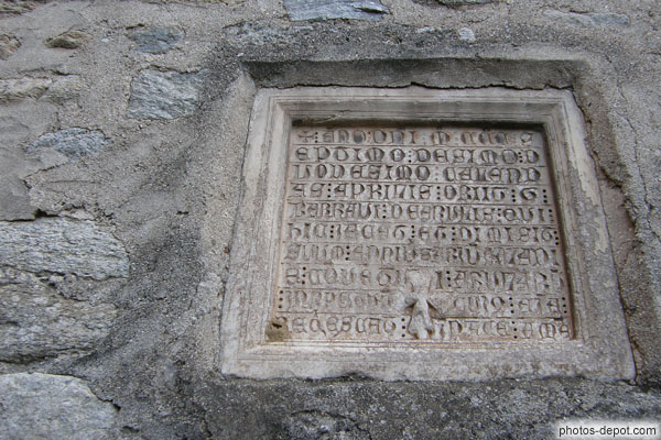 photo d'inscription latine gravée dans une pierre encastrée dans la facade