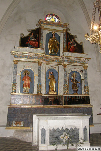 photo de Retable au fondateur de l'ordre bénédictin entouré de St Etienne et St Isidore et surmonté de la Vierge. Belle prédelle de toile peinte.