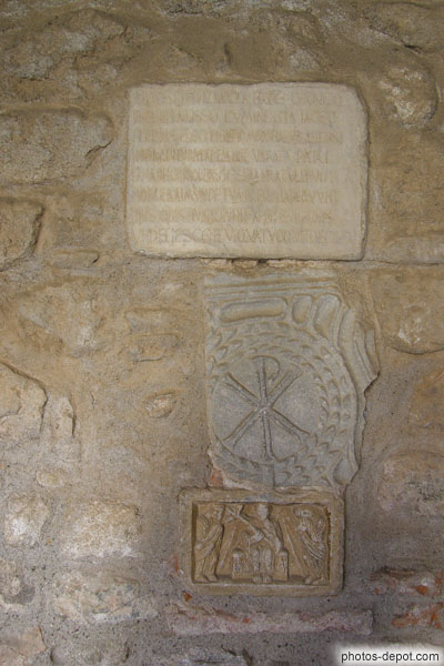photo de Chrisme et pierres gravées sur mur de l'abbaye dans le clôitre