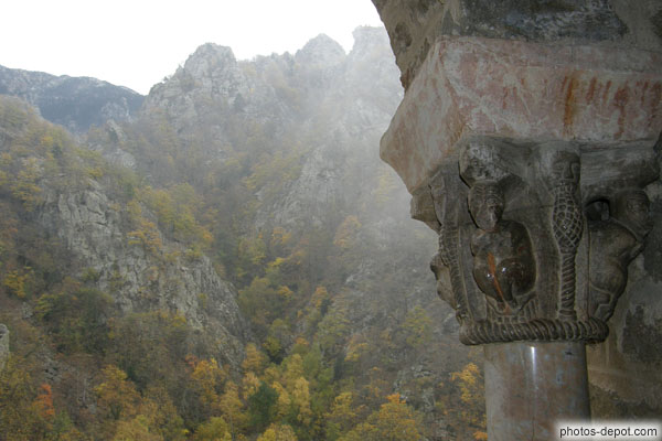 photo de chapiteaux sculptés du cloître s'ouvrant sur la montagne