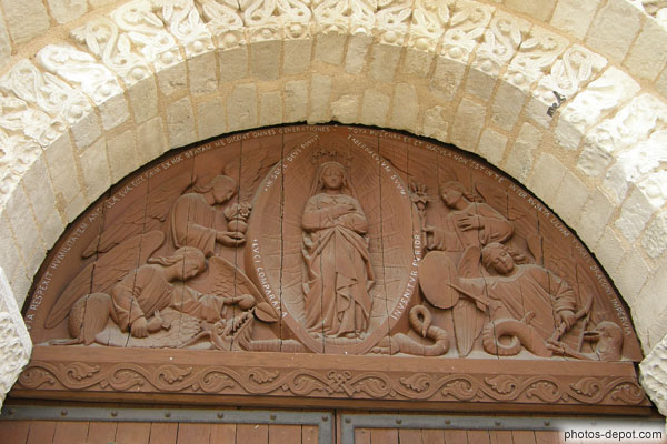 photo de sculpture surmontant la porte de l'église
