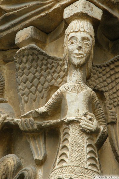 photo d'Ange au long cou tenant démon enchainé, sur chapiteau, détail