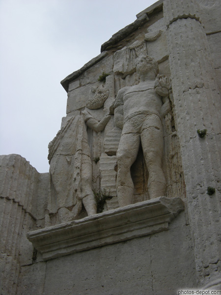 photo de captif enchaîné, symbole de la barbarie vaincue et personnage portant son sagum (manteau gaulois) à la manière d'une toge, symbole du ralliement à Rome des notables gaulois