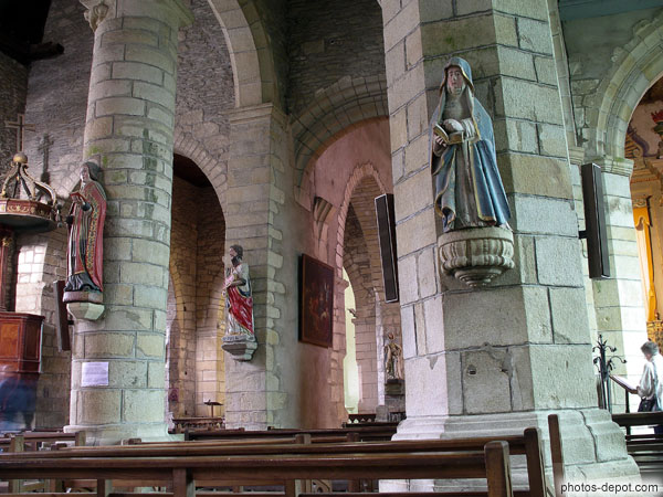 photo d'intérieur de la collégiale romane et statues aux murs