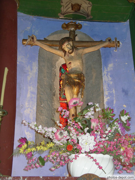 photo de Christ en croix, polychrome, et belle composition florale