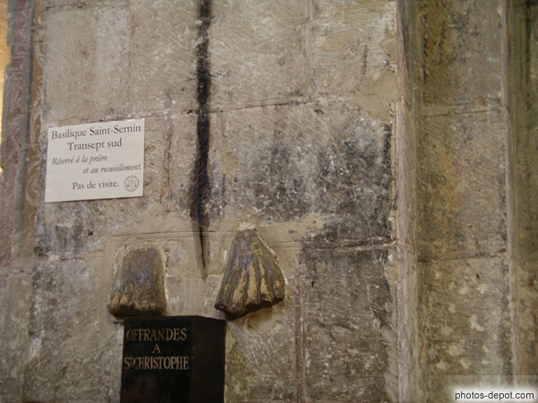 photo de Pieds enchassés dans la pierre et offrandes à st Christophe
