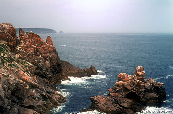 photo de roches rouges découpées sur mer bleue