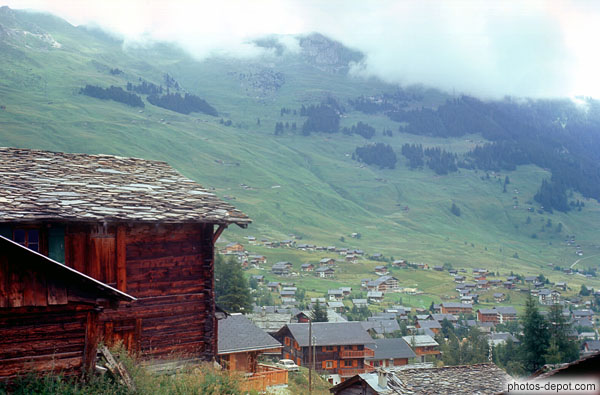 photo de châlet de bois rouge devant la vallée, Verbier