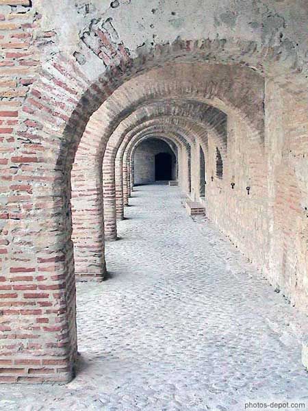 Arches de brique et cour en galets