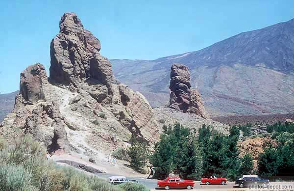 photo de Pic rocheux dominant les voitures sur la route de montagne