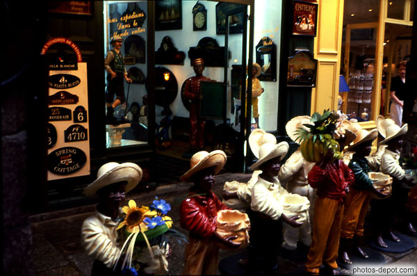 photo de devanture de magasin aux statues d'enfants noirs portant des chapeaux