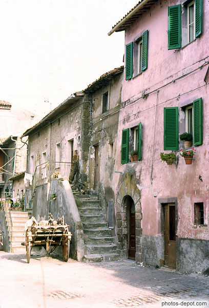 photo de charette devant escalier et maison rose