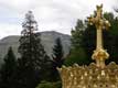Croix dorée et couronne à la Vierge devant la colline