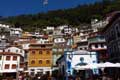 Maisons étagées multicolores à flanc de falaise au fond d'une crique formant le village / Espagne, Cote Cantabrique, Cudillero